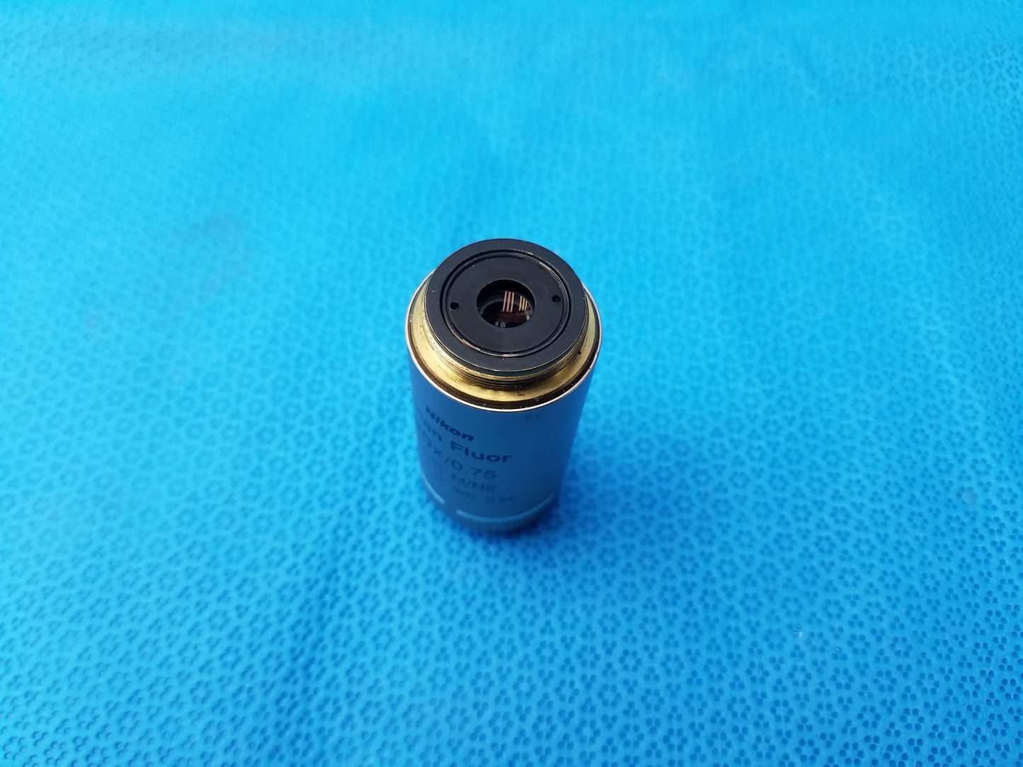 Silver Nikon plan fluor microscope objective lens with gold-colored rim and black top ring compatible Nikon models