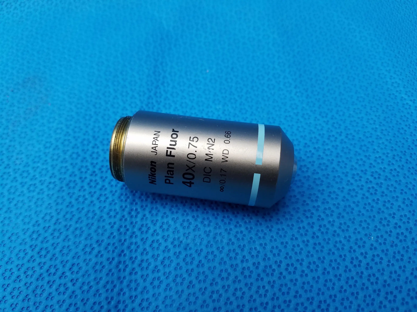 Silver Nikon plan fluor 40x/0.75 microscope objective lens with blue accents and gold threaded mount compatible Nikon