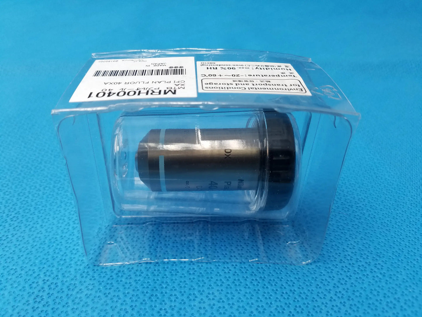 A metallic nikon plan fluor 40x microscope objective with black threaded cap labeled mr100401 for scientific imaging