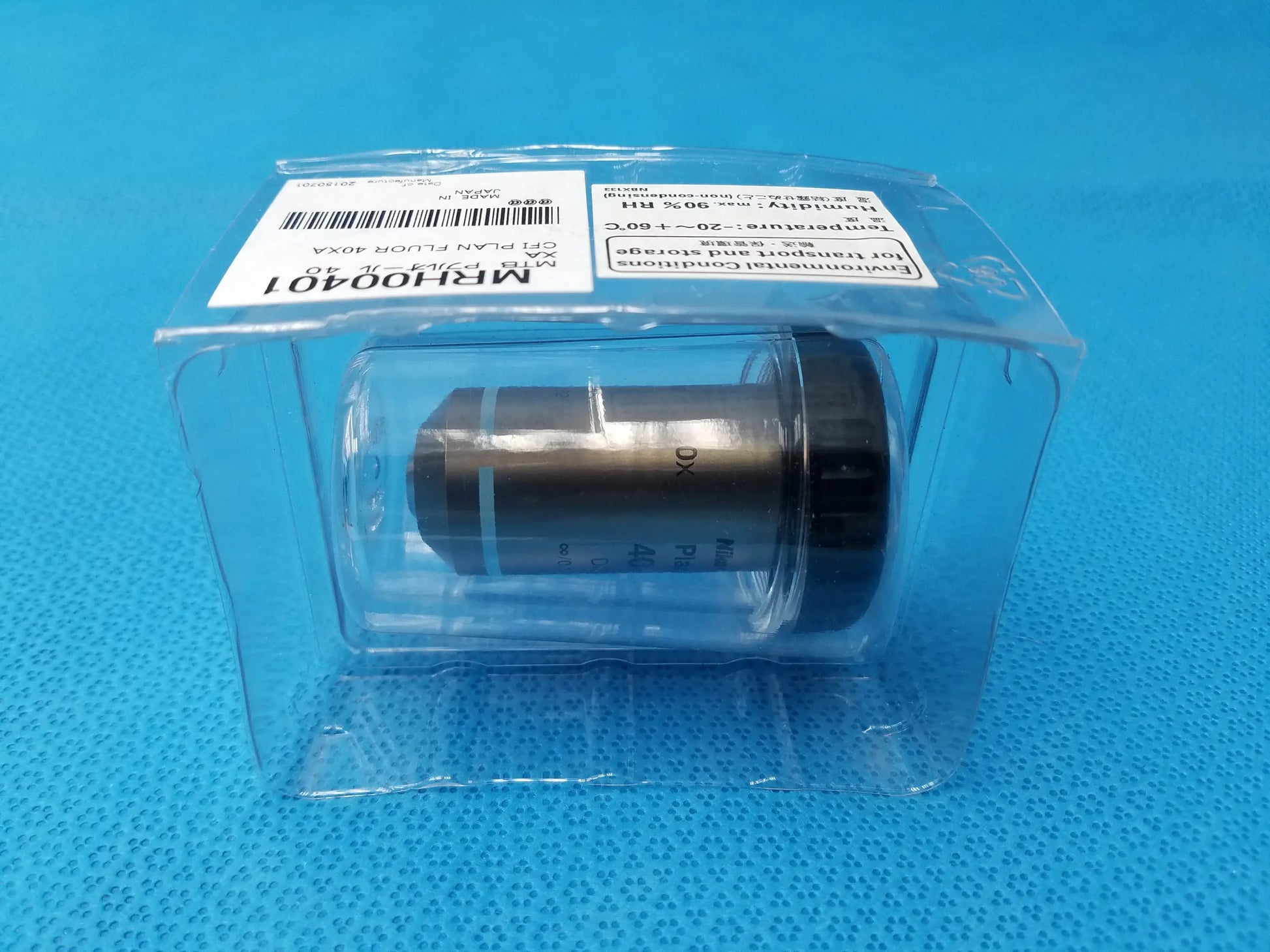 A metallic nikon plan fluor 40x microscope objective with black threaded cap labeled mr100401 for scientific imaging