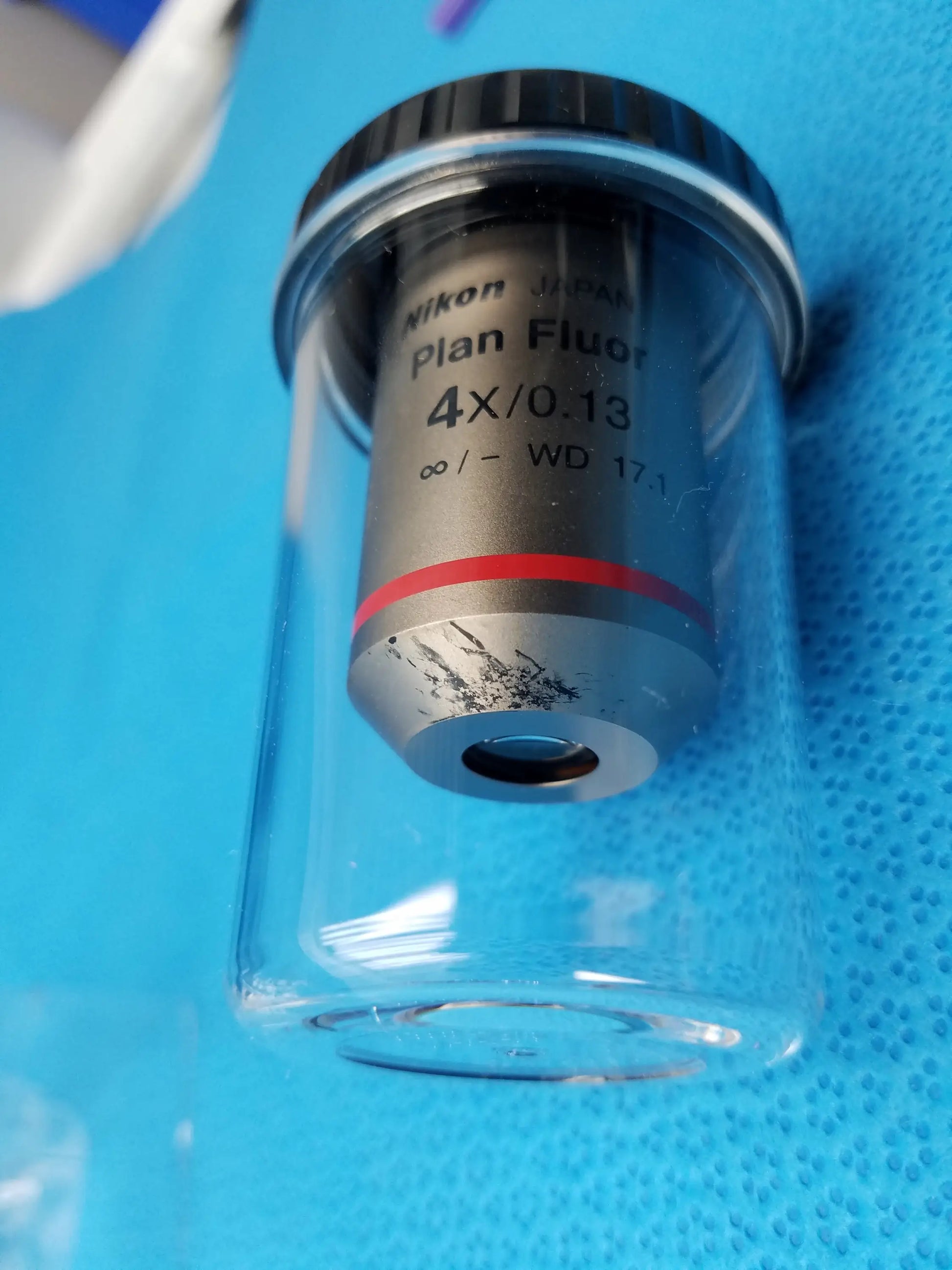 Nikon plan fluor 4x/0.13 microscope objective with silver body and red ring in clear protective case compatible Nikon