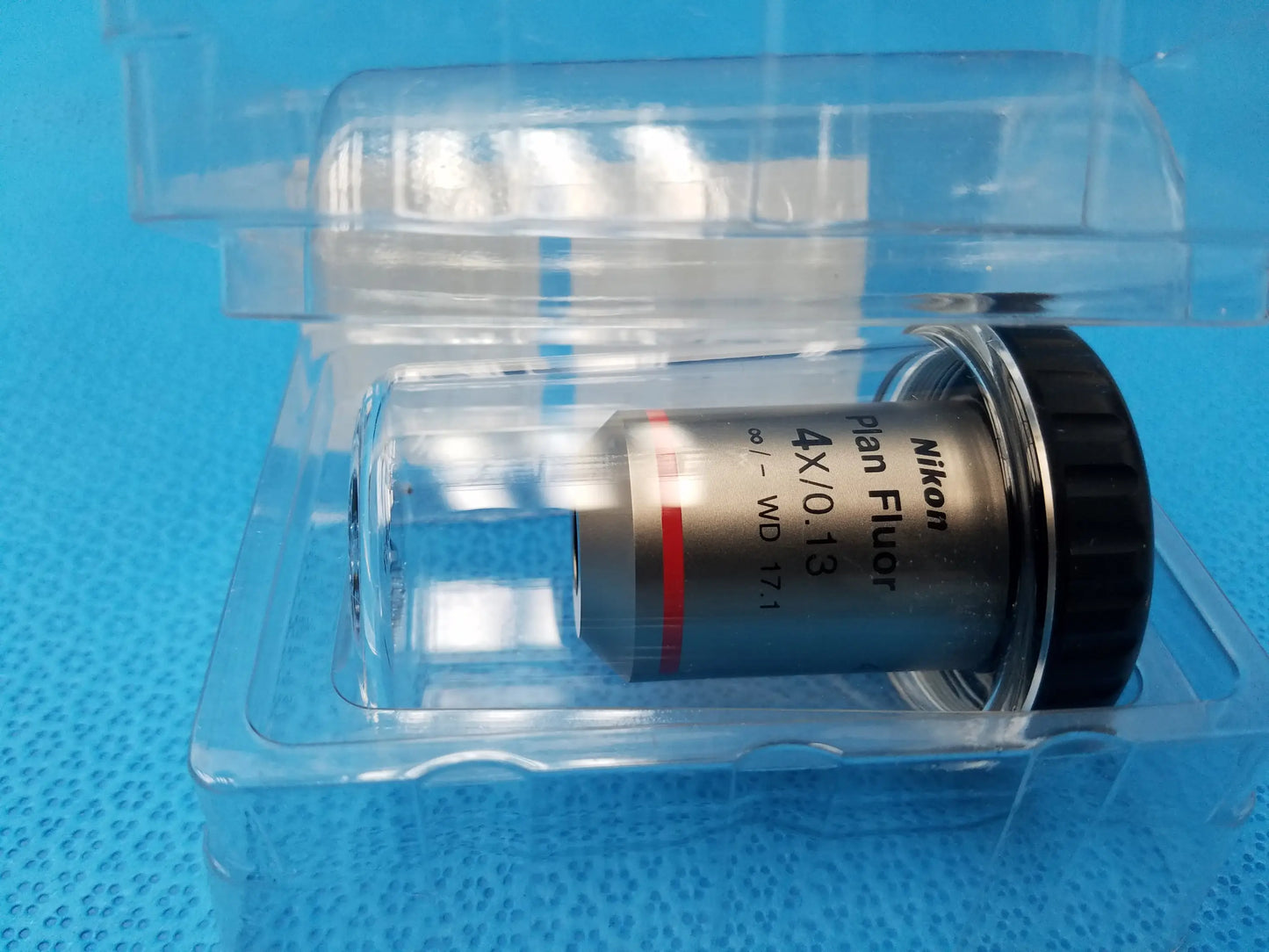 Nikon plan fluor 4x 0.13 microscope objective with black metallic body in clear plastic packaging compatible Nikon