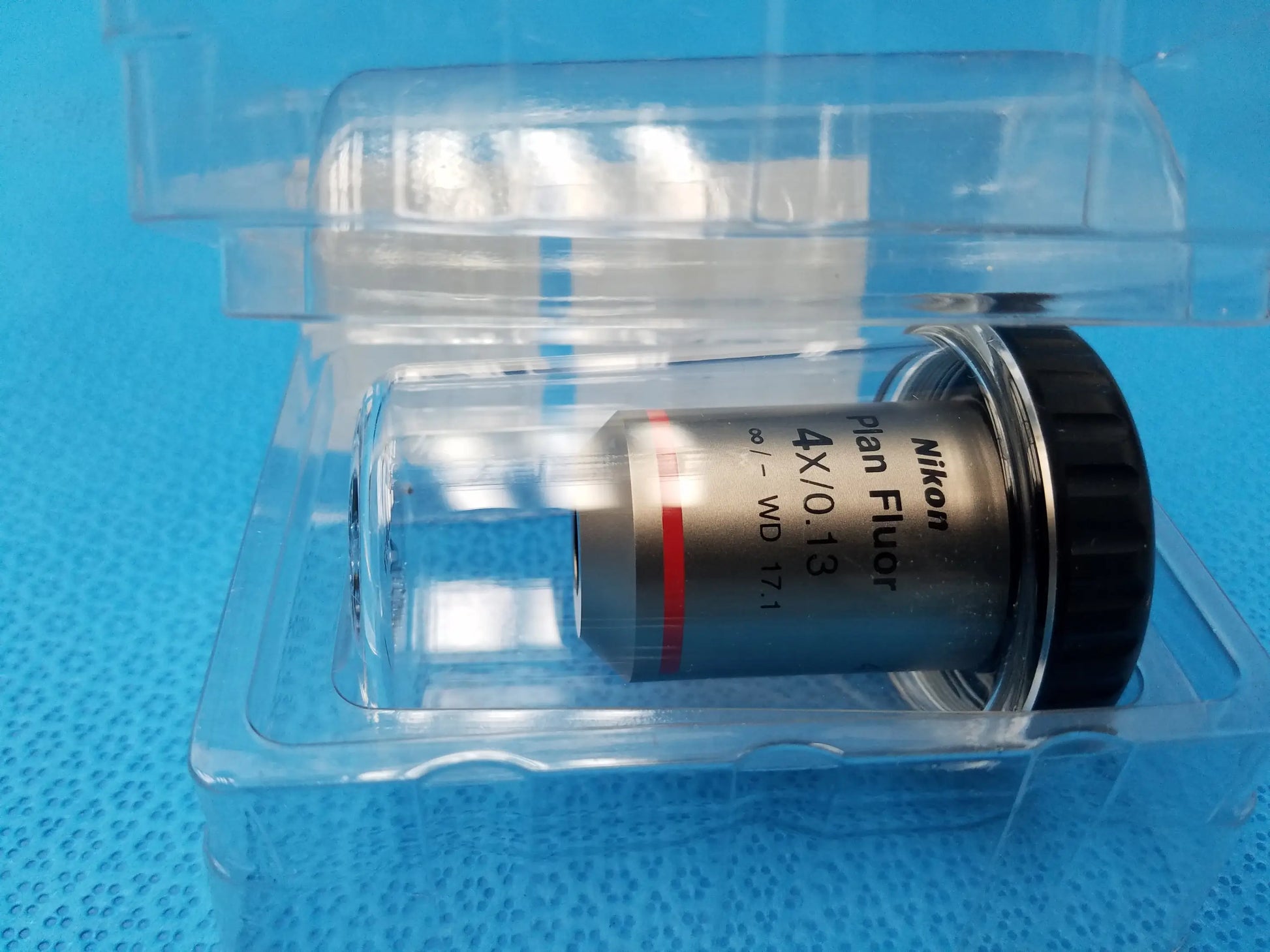 Nikon plan fluor 4x 0.13 microscope objective with black metallic body in clear plastic packaging compatible Nikon