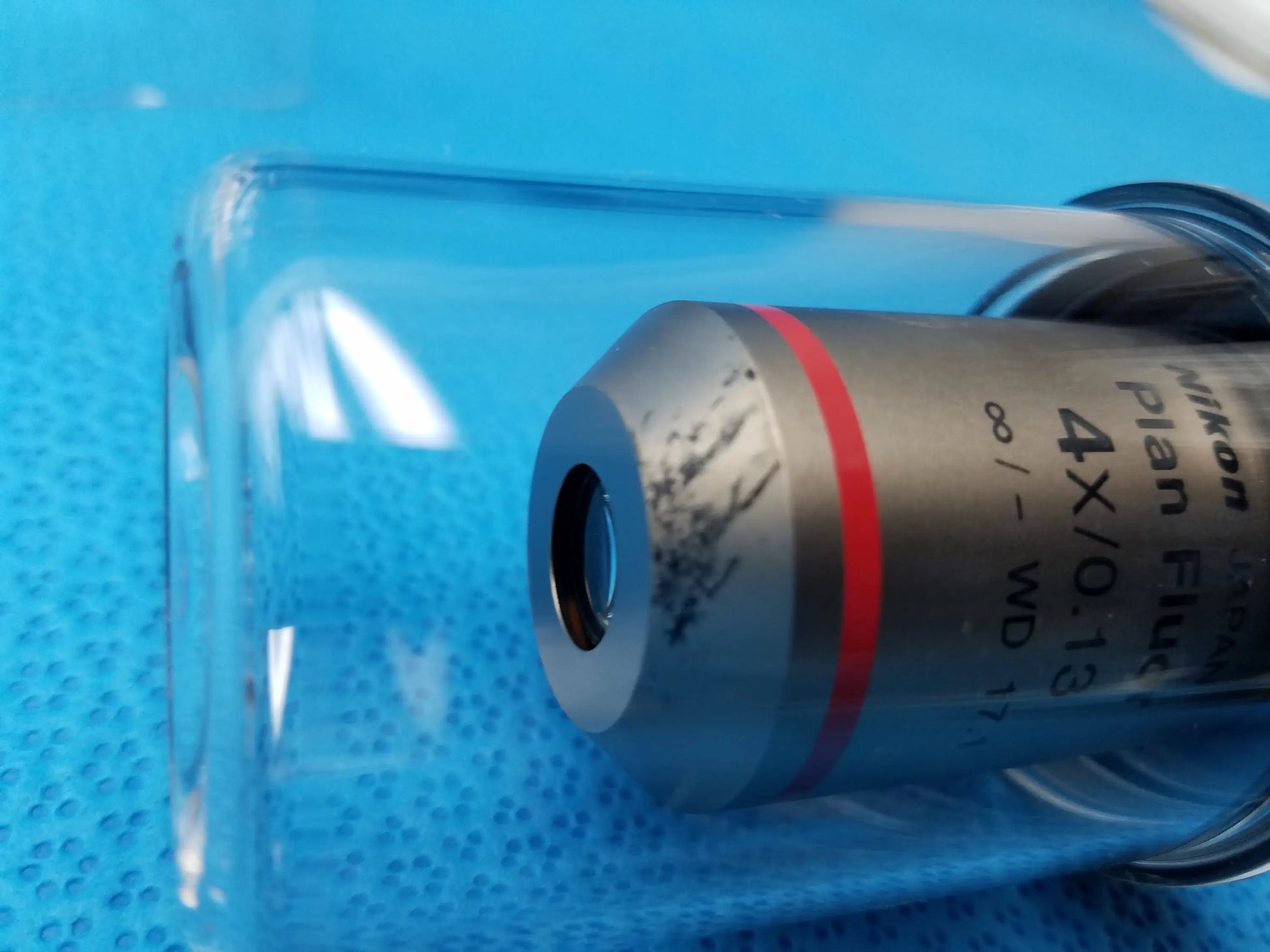 Nikon plan fluor 4x 0.13 microscope objective with red ring and metallic body in clear protective casing compatible Nikon