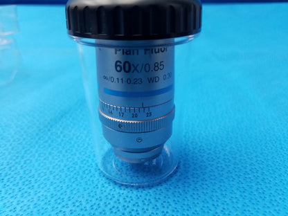 Silver-colored Nikon plan fluor 60x/0.85 microscope objective with black cap in clear protective casing compatible Nikon