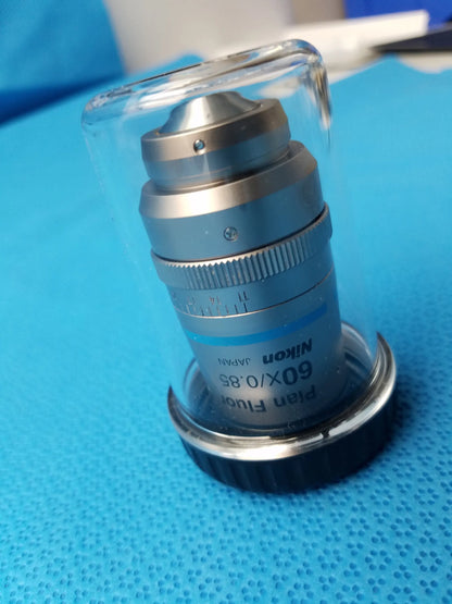 Nikon plan fluor 60x/0.85 microscope objective with metallic silver body and black accents in clear protective casing compatible Nikon