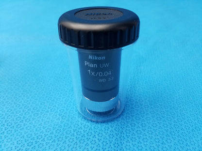 Nikon plan uw 1x 0.04 microscope objective lens with black threaded cap and clear protective casing for compatible nikon microscope systems