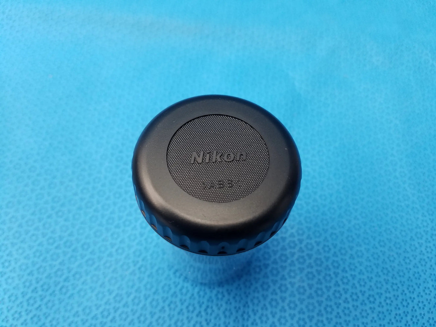 Black nikon lens cap with textured grip and embossed logo for compatible nikon microscope systems and microscope systems
