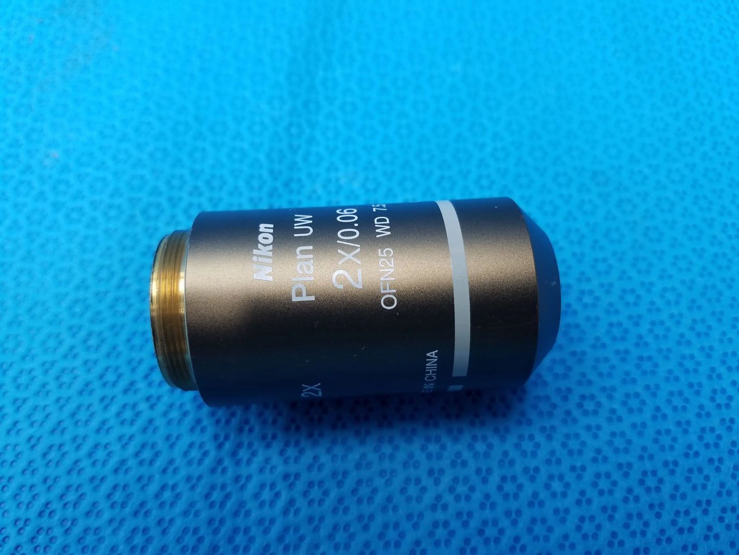 Nikon plan uw 2x microscope objective lens with black body gold threaded mount numerical aperture 0.06 working distance 7.5 mm
