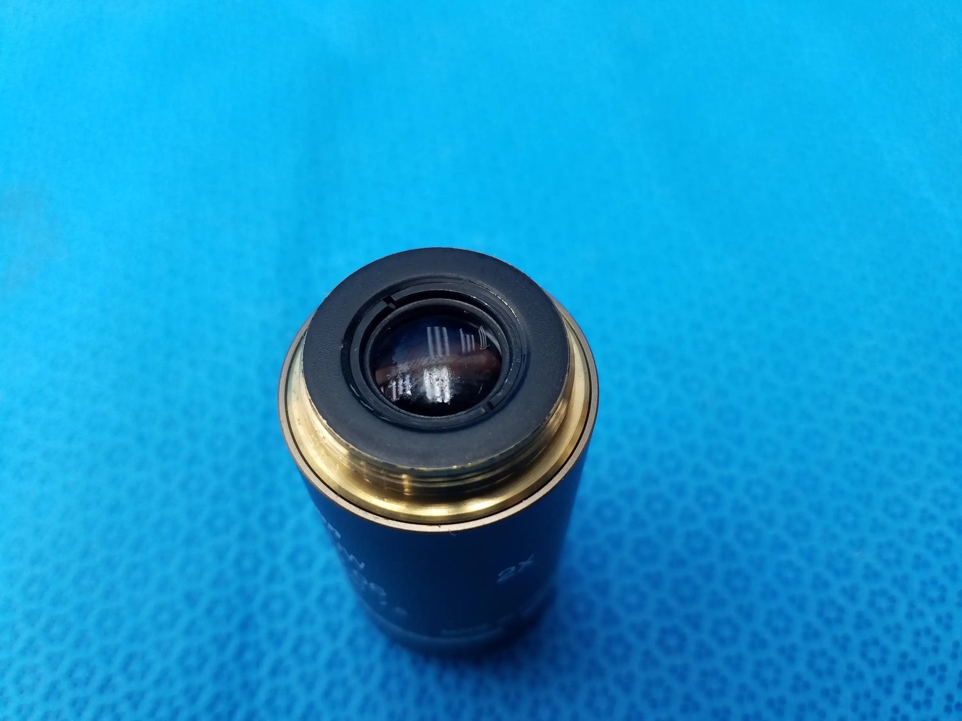 Black and gold Nikon Plan UW 2x/0.06 microscope objective lens with threaded mounting ring featuring numerical aperture and 7.5 mm working distance