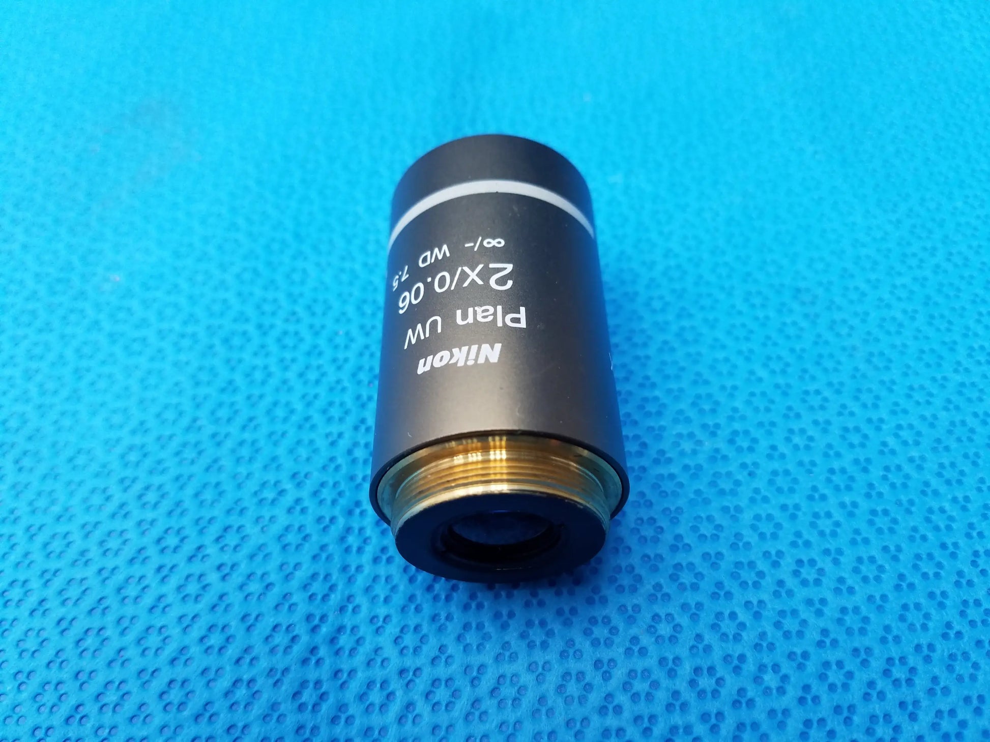 Nikon plan uw 2x microscope objective lens with black matte finish, gold threaded mount, numerical aperture 0.06, working distance 7.5mm