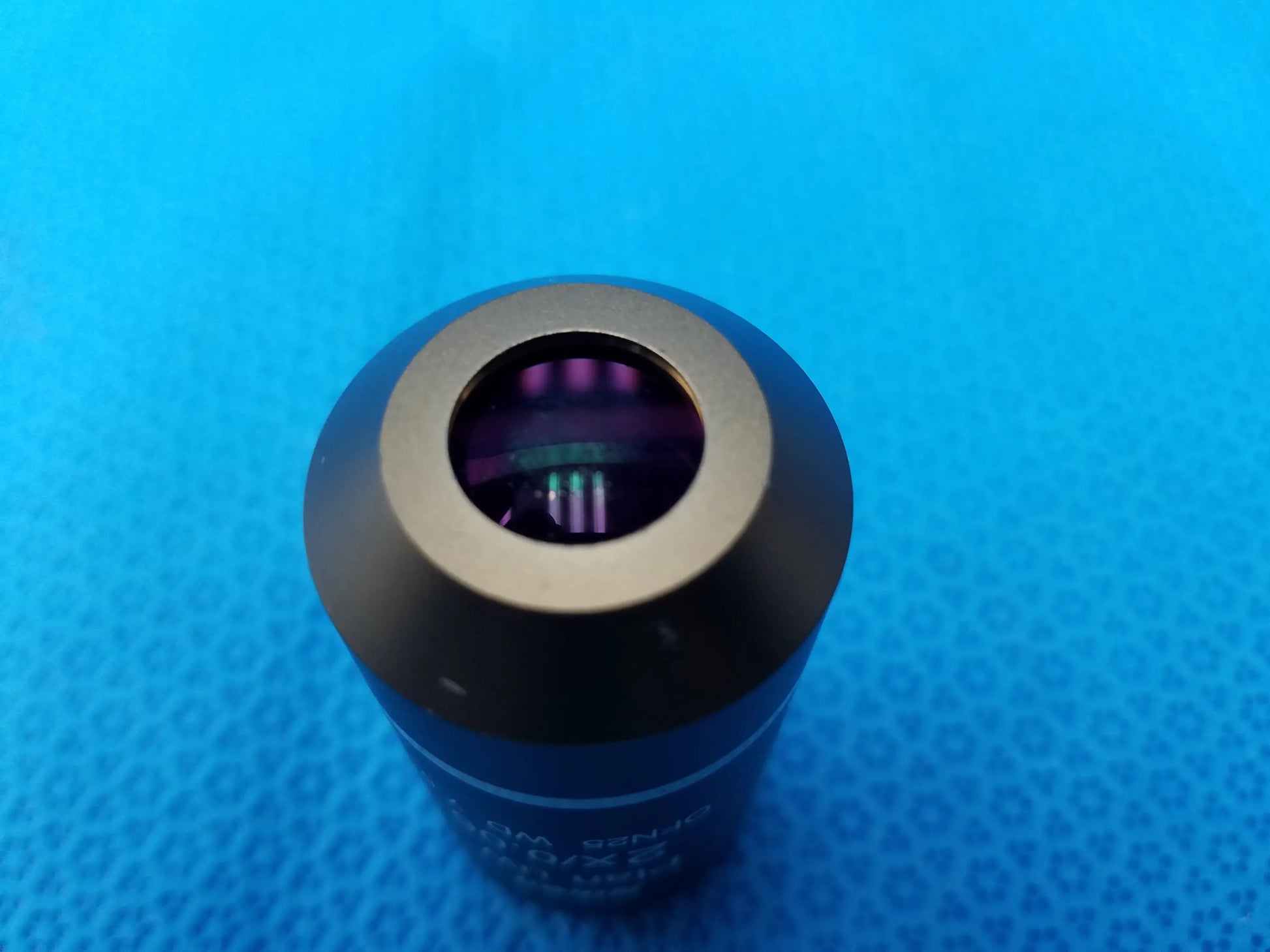 Black cylindrical Nikon Plan UW 2x microscope objective lens with metallic ring, purple glass, 0.06 numerical aperture, 7.5 mm working distance