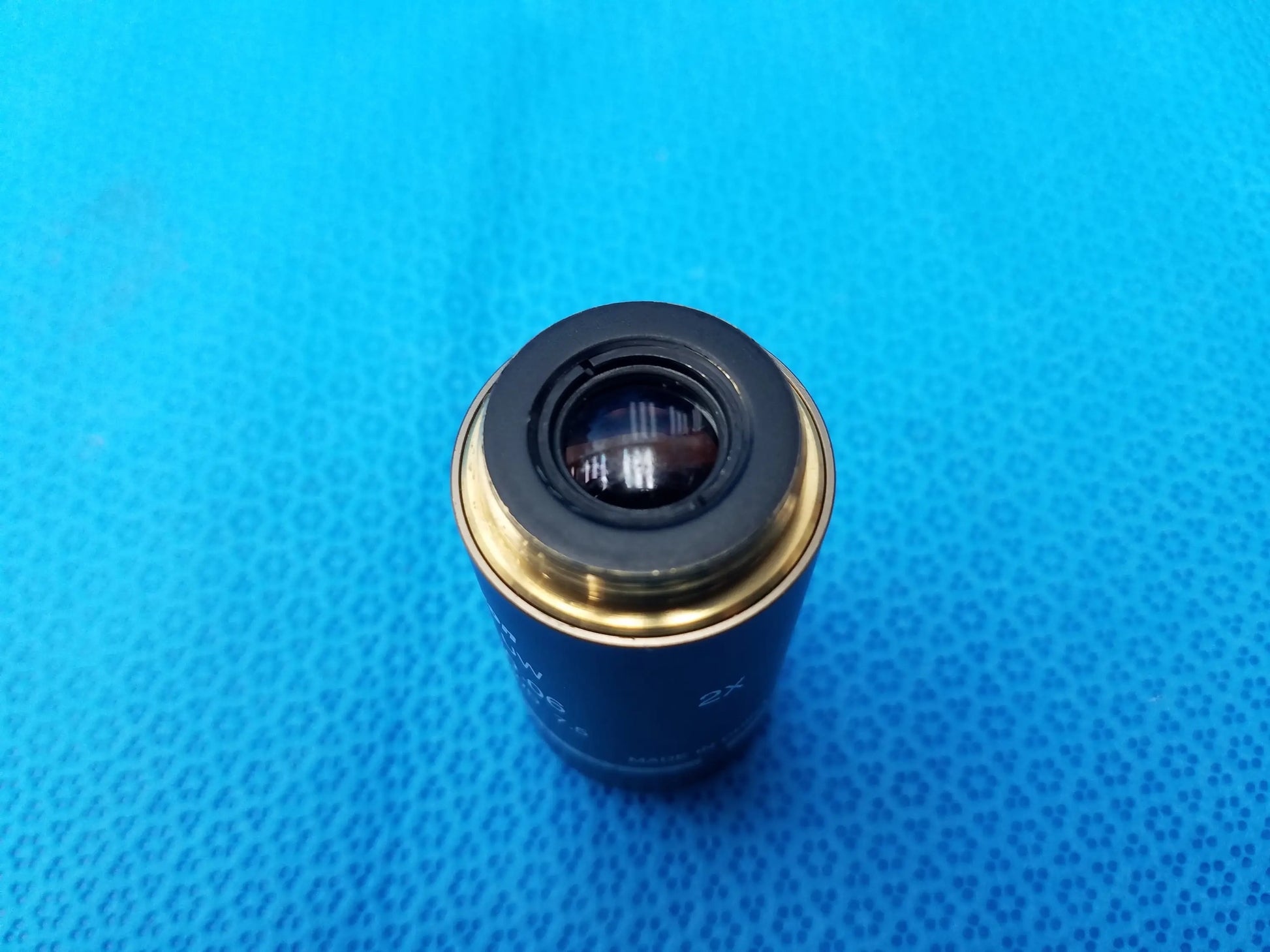 Black and gold Nikon Plan UW 2x microscope objective lens with numerical aperture 0.06 and working distance 7.5 mm