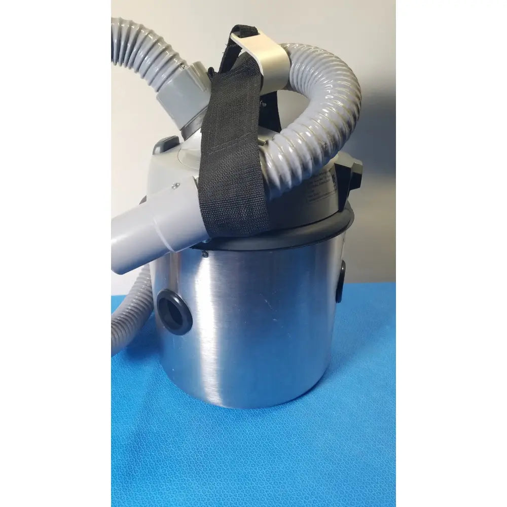 Silver cylindrical Nilfisk HoverMatt Air supply unit with gray flexible hoses and black straps for efficient vacuum cleaning