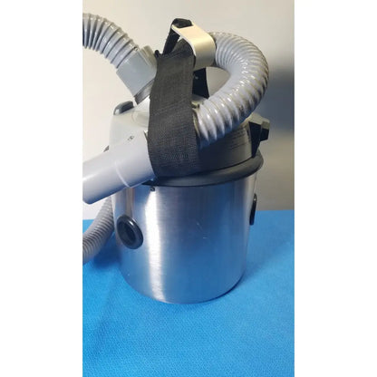 Silver cylindrical Nilfisk HoverMatt Air supply unit with gray flexible hoses and black straps for efficient vacuum cleaning