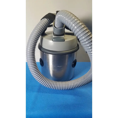 Gray corrugated hose loops around cylindrical stainless steel nilfisk hovermatt air supply unit with gray plastic top