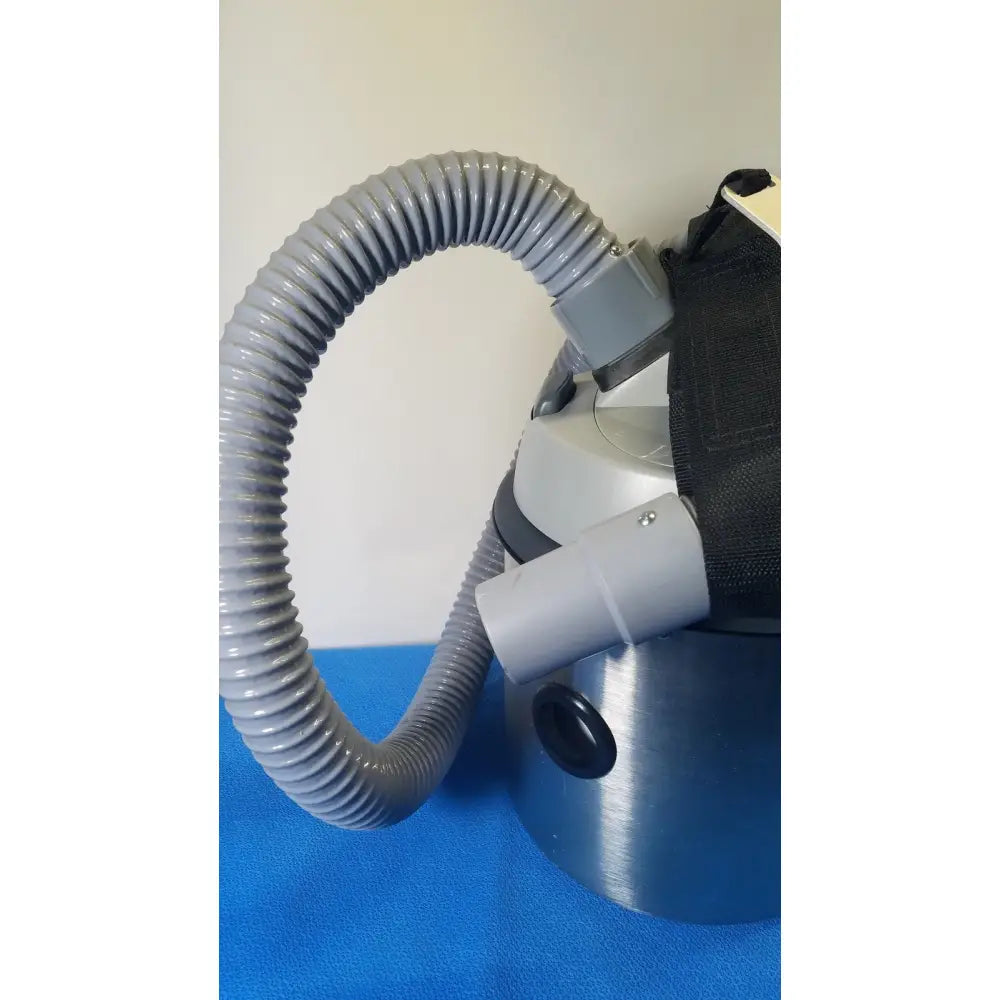 Gray corrugated hose attached to the silver metallic nilfisk hovermatt air supply unit with black accents