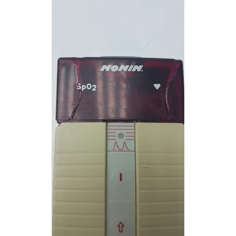 Maroon and beige nonin spo2 handheld pulse oximeter model 8500m with ridged plastic sides and heart icon display panel