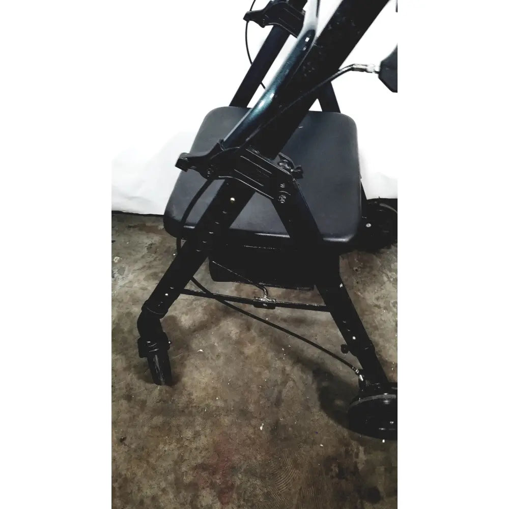 Black metal nova lightweight transport chair with padded seat and four wheels suitable for 300lbs capacity use