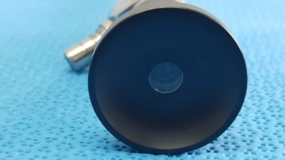 Black circular lens with central aperture in metallic housing of novadaq sc9104 autoclavable laparoscope endoscope