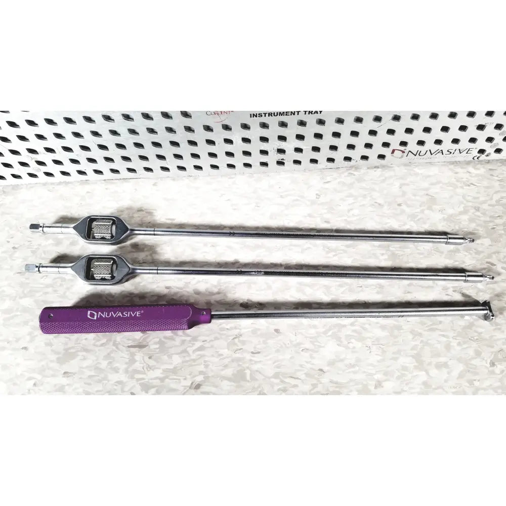 Three metallic surgical instruments with purple and silver handles in the nuvasive speed innovation coroent xl-fixation tray