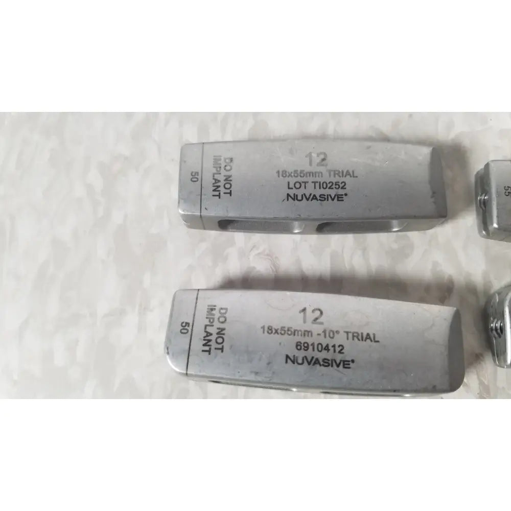 Silver metallic dental implant trial fixtures with engraved markings and nuvasive brand name for xlif x1 instrument tray