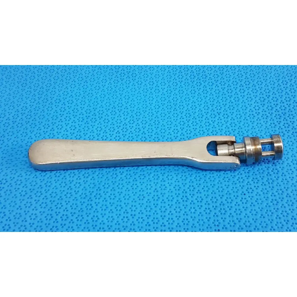 Silver-colored metal octobase retractor handle with adjustable jaw mechanism for surgical retractor positioning