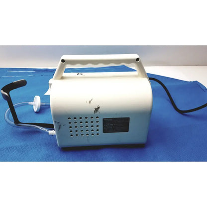 White plastic Ohio Care-E-VAC 3 portable suction pump medical unit with black handle and tubing for medical use