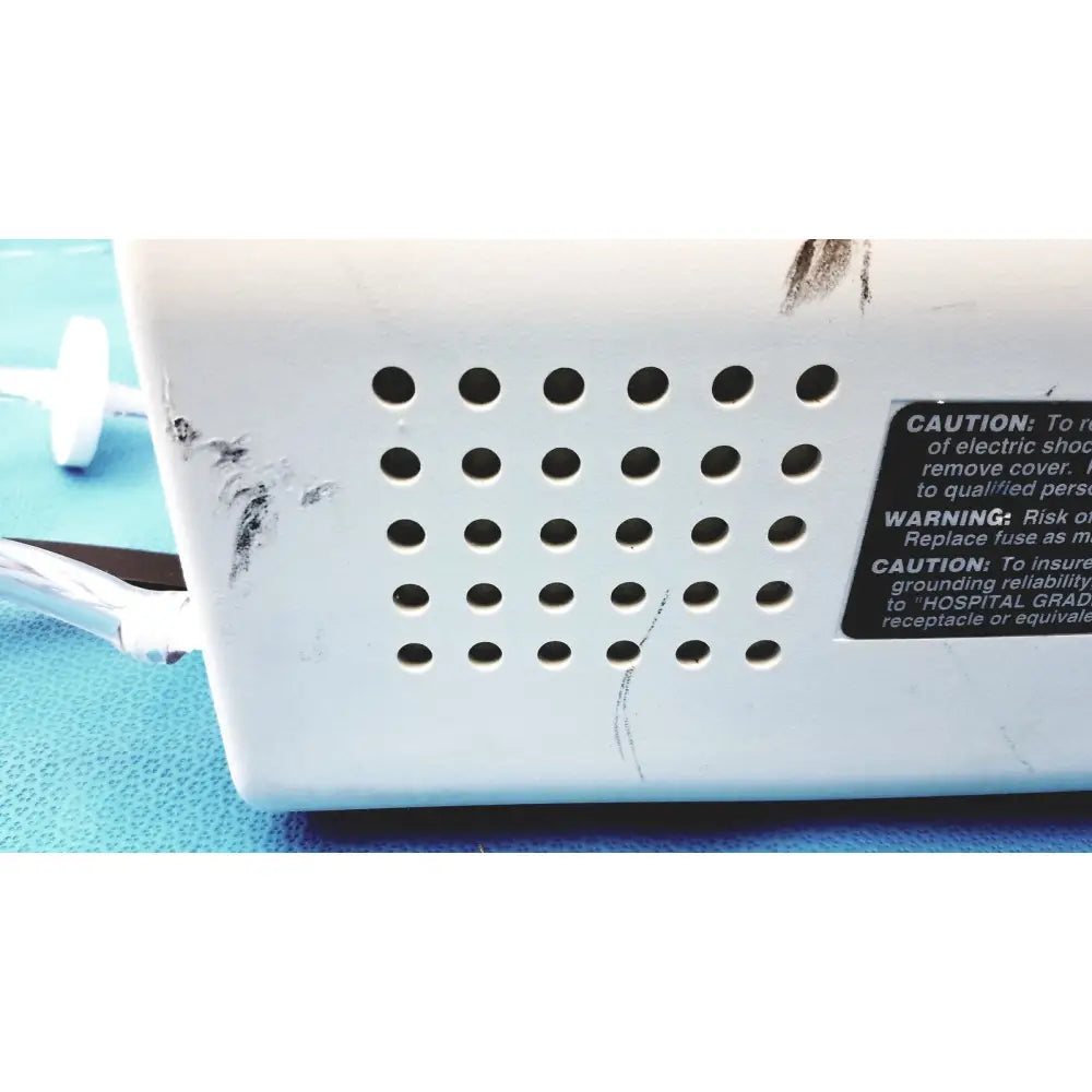 White plastic back side of ohio care e vac 3 portable suction pump medical unit with circular ventilation holes and wear marks