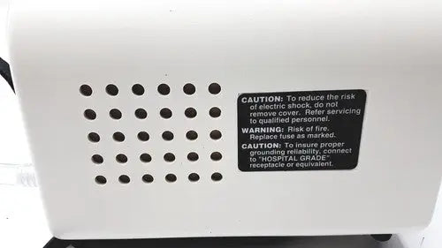 White plastic back side of ohio medical care-e-vac 3 portable suction device with black caution label and ventilation holes