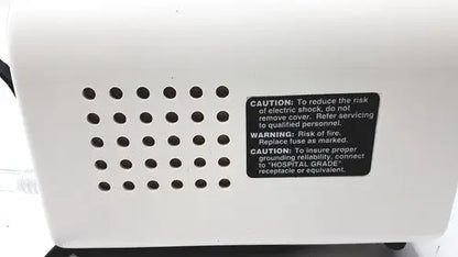White plastic back side of ohio medical care-e-vac 3 portable suction device with black caution label and ventilation holes