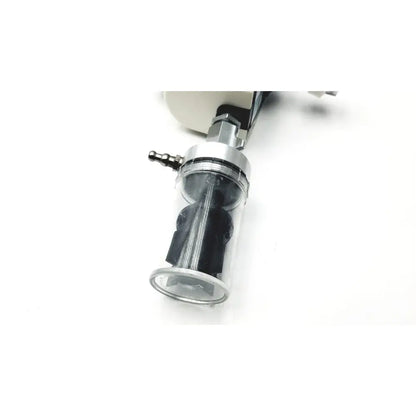 Clear cylindrical air filter with black internal parts and metallic fittings in ohio medical vacuum regulator model 1251