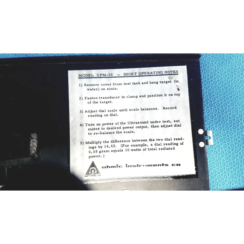 Black plastic case of ohmic instruments upm-30 ultrasound power meter scale with white label showing operating instructions