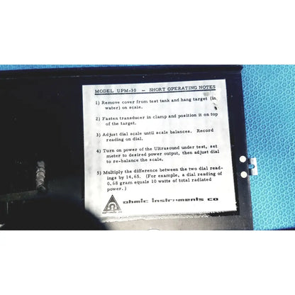 Black plastic case of ohmic instruments upm-30 ultrasound power meter scale with white label showing operating instructions