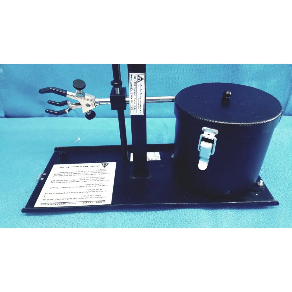 Black cylindrical ohmic instruments ultrasound power meter with white latch and adjustable metal stand clamp