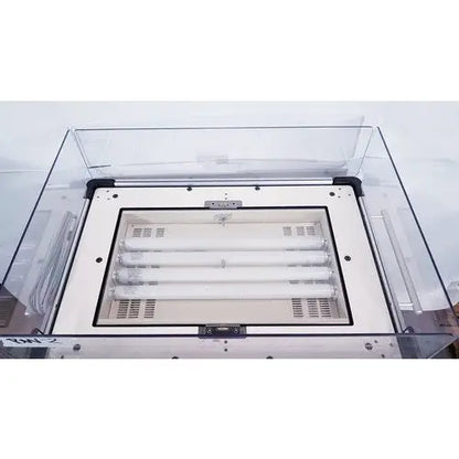 Clear acrylic protective cover over white industrial lighting fixture with four fluorescent tubes on olympic medical bili-bassinet phototherapy unit