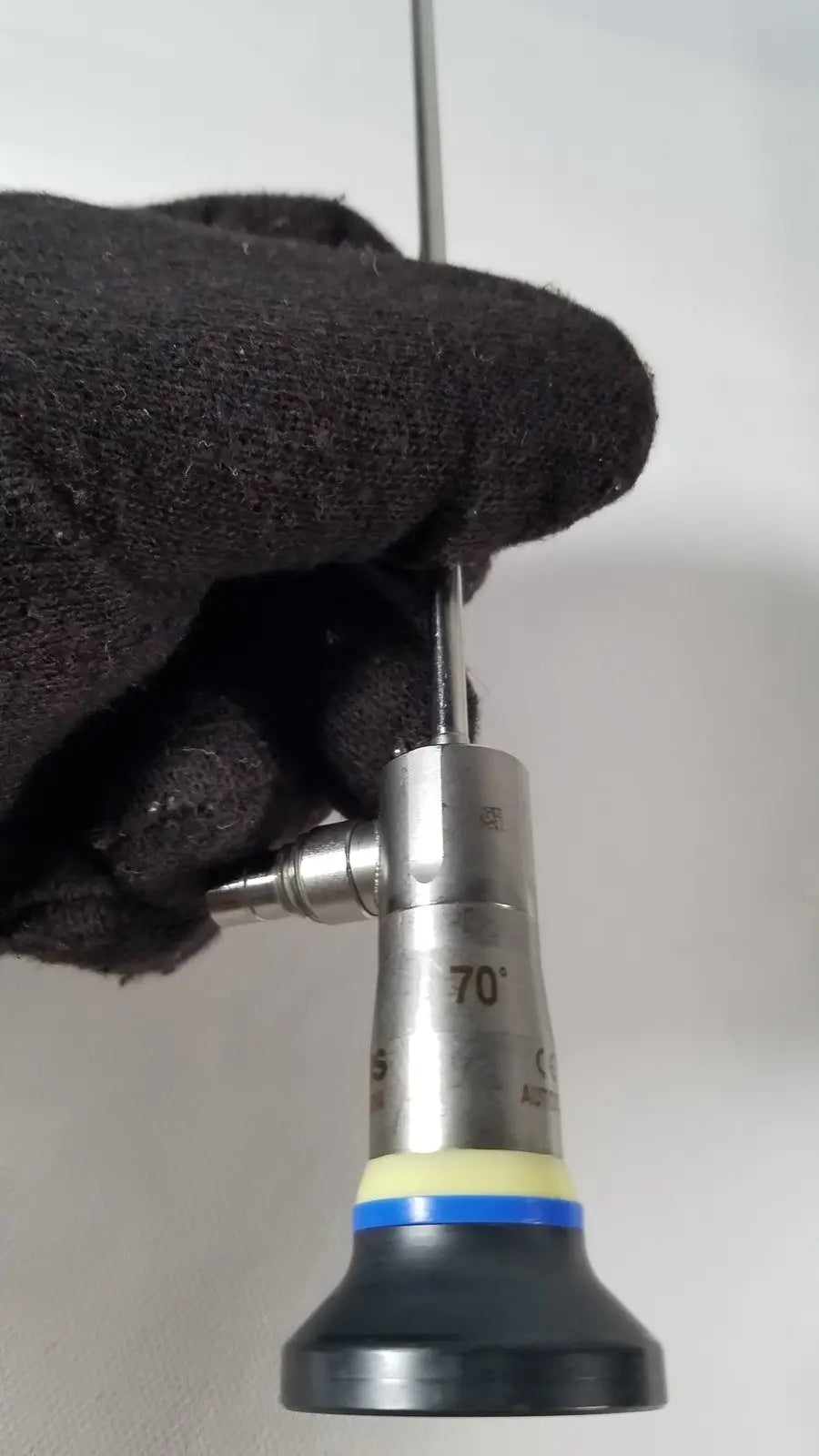Silver surgical endoscope olympus a1933a 4mm with 70-degree angled tip black rubber grip and yellow-blue accent bands