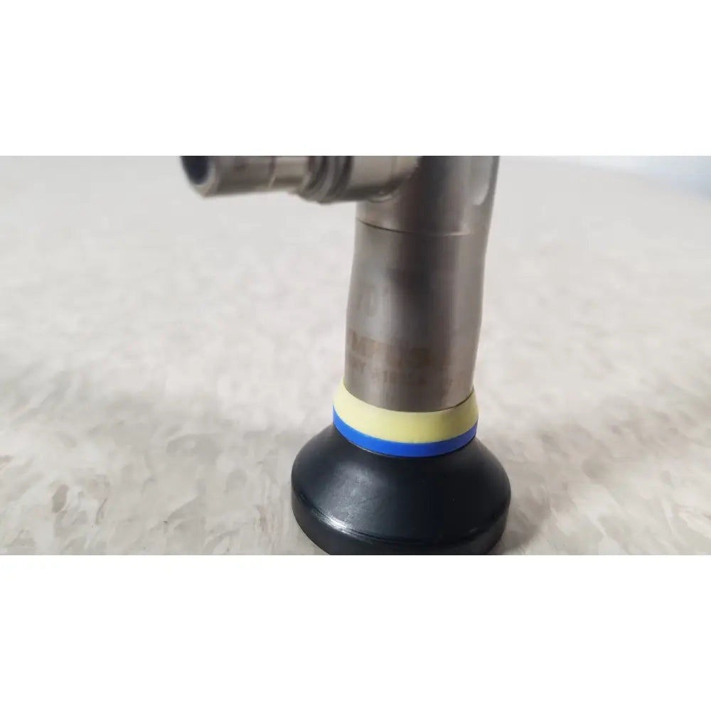 Black rubber suction cup with yellow and blue bands attached to metallic pipe of olympus a1933a autoclavable rigid scope