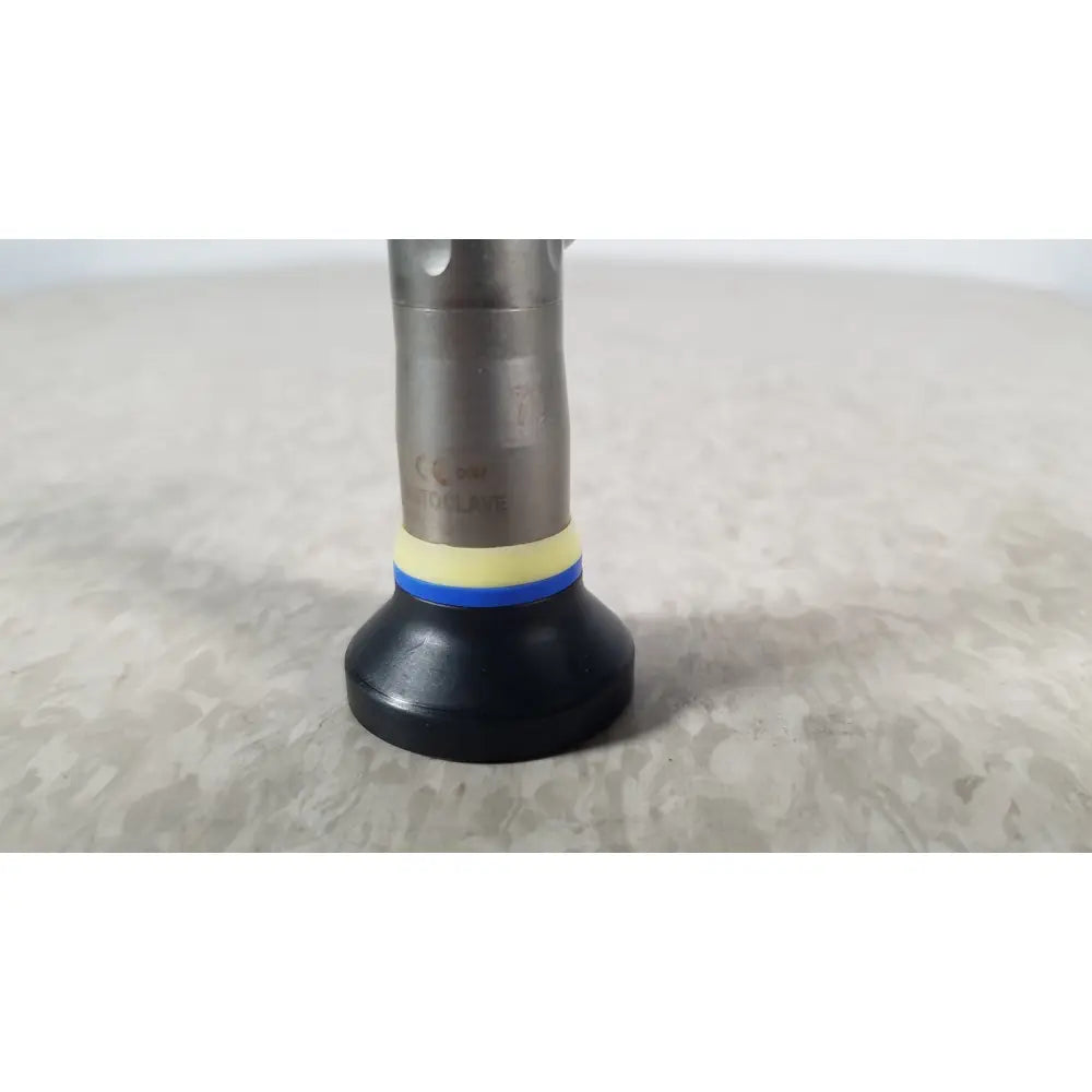 Silver metallic olympus a1933a autoclavable rigid scope with black rubber base and yellow-blue striped accent ring