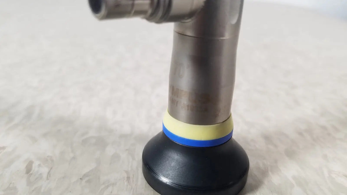 Black rubber suction cup with yellow and blue bands attached to metallic pipe of olympus a1933a autoclavable rigid scope
