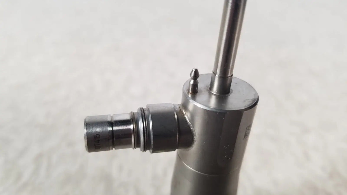 Silver metallic medical-grade syringe with cylindrical barrel and threaded plunger in olympus a1933a autoclavable scope