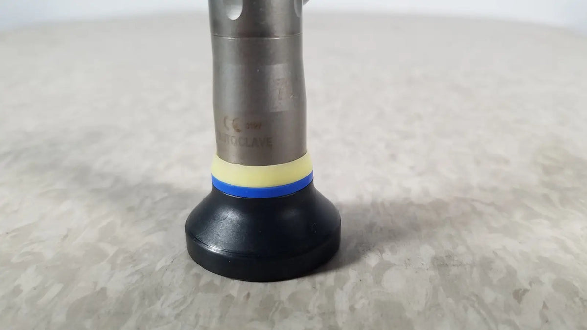 Silver metallic olympus a1933a autoclavable rigid scope with black rubber base and yellow-blue striped accent ring