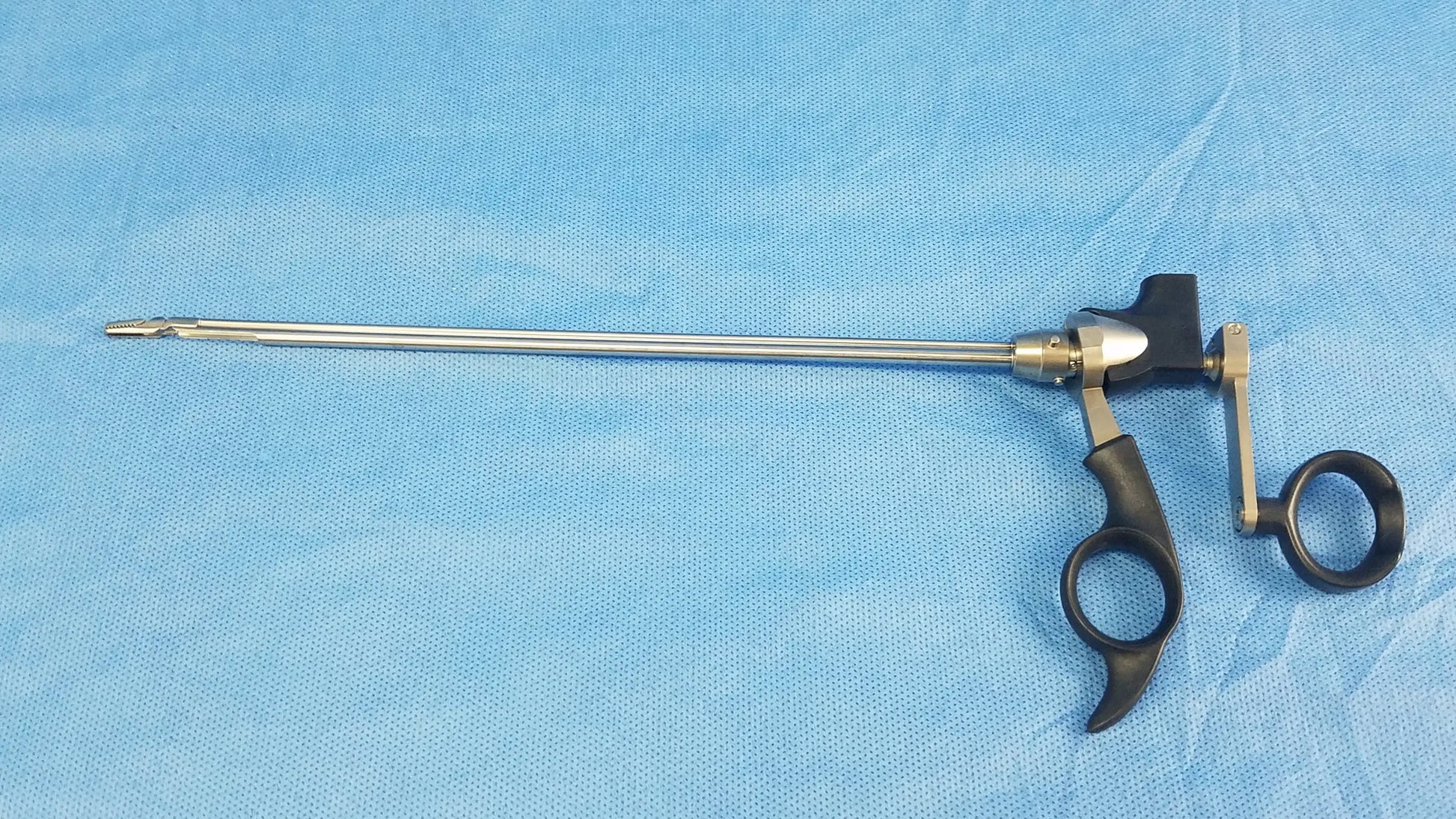 Olympus A20718A optical grasping forceps with silver metal body, black ergonomic handles, and curved metallic joints