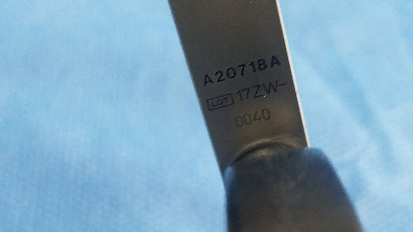 A stainless steel Olympus a20718a optical grasping forceps blade with engraved lot number and dark handle