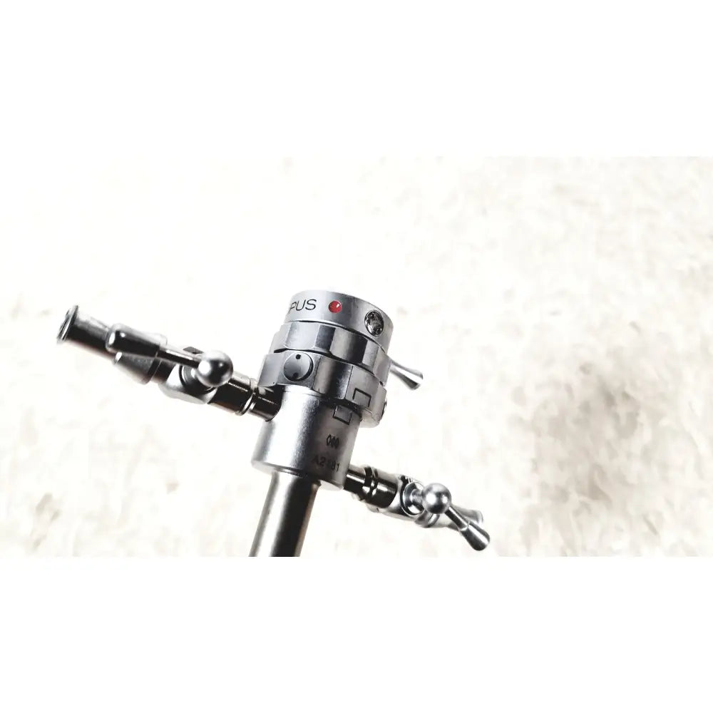 Silver metallic olympus a2181 endoscope sheath with cylindrical body and dual articulated arms with spherical joints