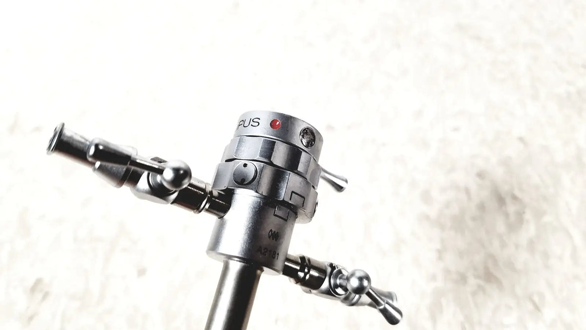 Silver metallic olympus a2181 endoscope sheath with cylindrical body and dual articulated arms with spherical joints