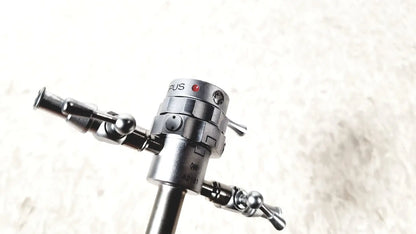 Silver metallic olympus a2181 endoscope sheath with cylindrical body and dual articulated arms with spherical joints