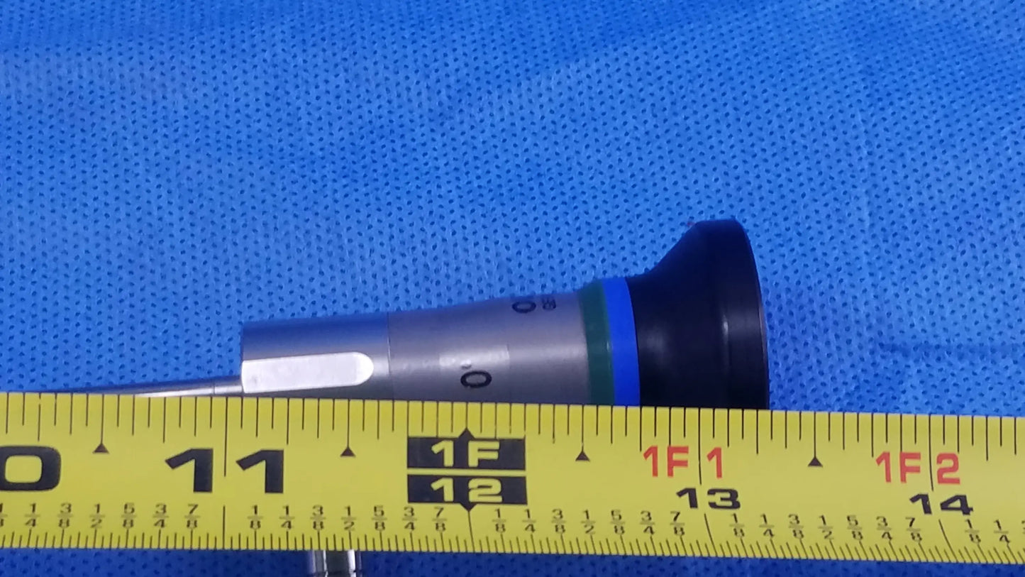 Silver and black compatible olympus cystoscopic a22000a autoclave cystoscope with blue ring resting beside yellow measuring tape