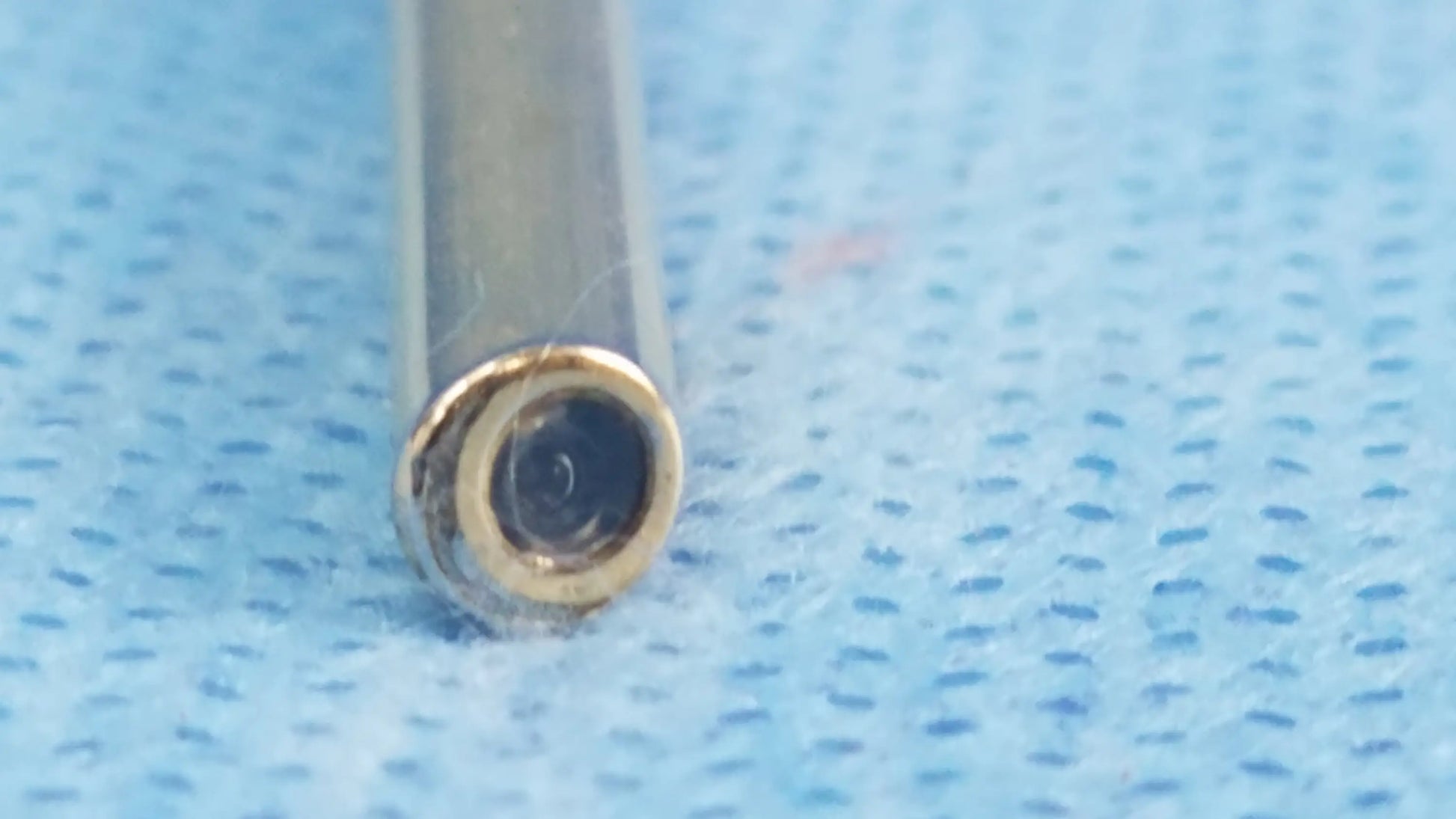 A close-up of a slender metallic gold-rimmed aperture on an a22002a compatible olympus cystoscopic lens