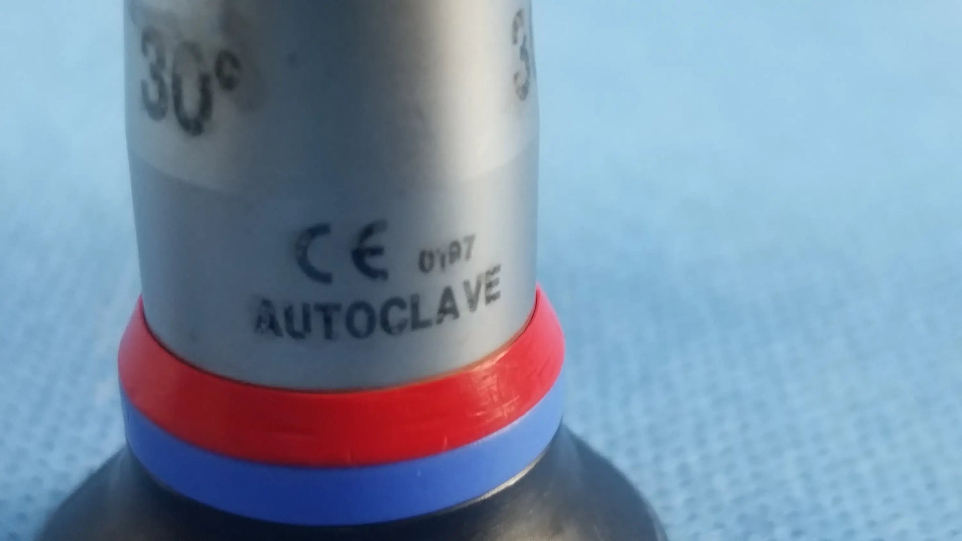Silver cylindrical autoclave valve with red and blue rubber seals for compatible olympus cystoscopic systems a22002a